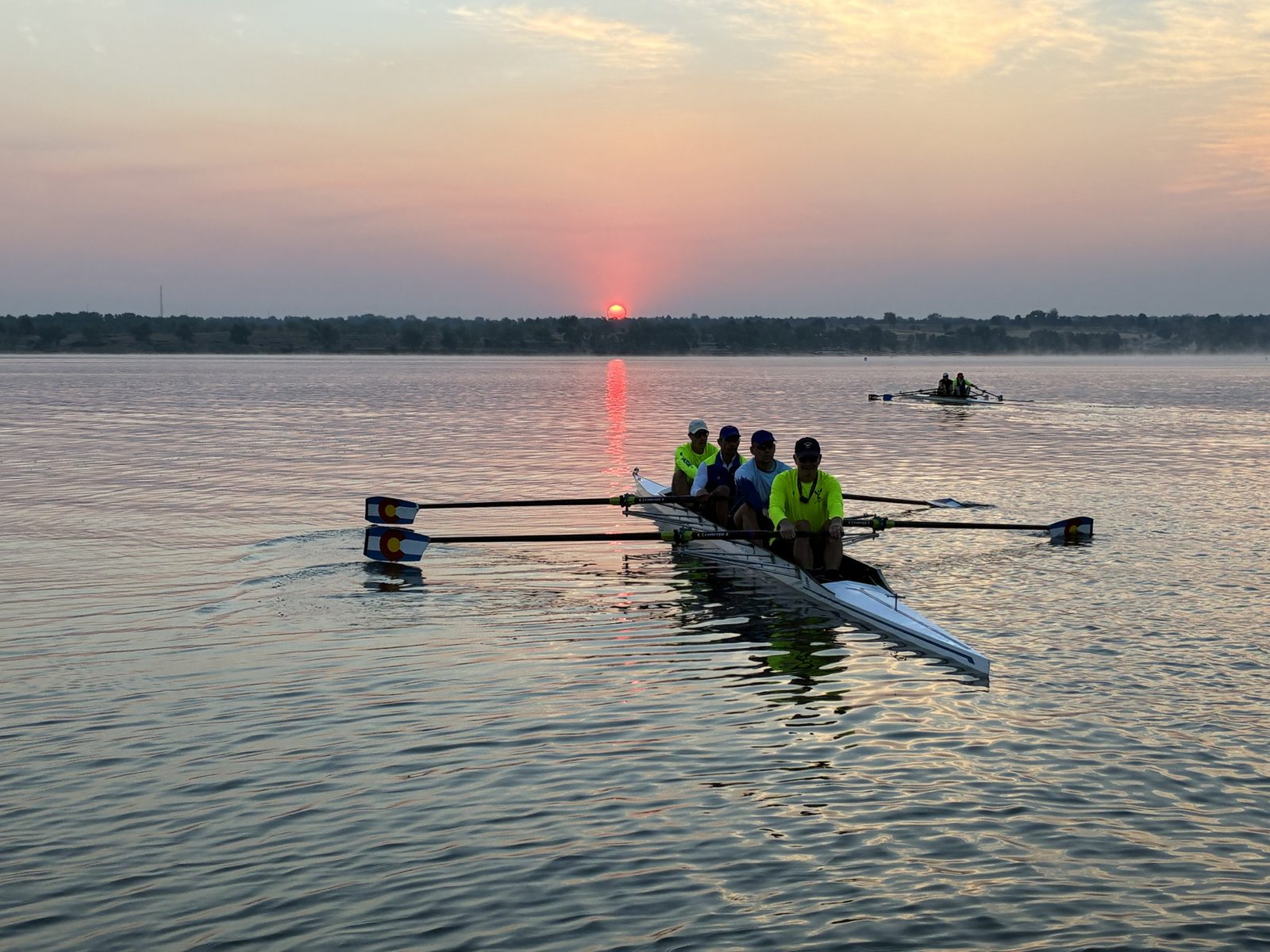 Dan rowing in a crew boat at sunrise on a Colorado reservoir